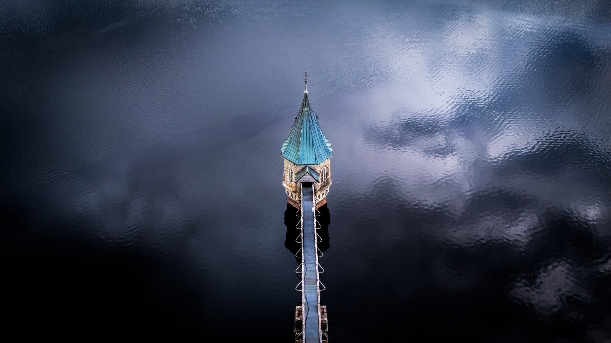 Minimal aerial photograph of a tower in still water